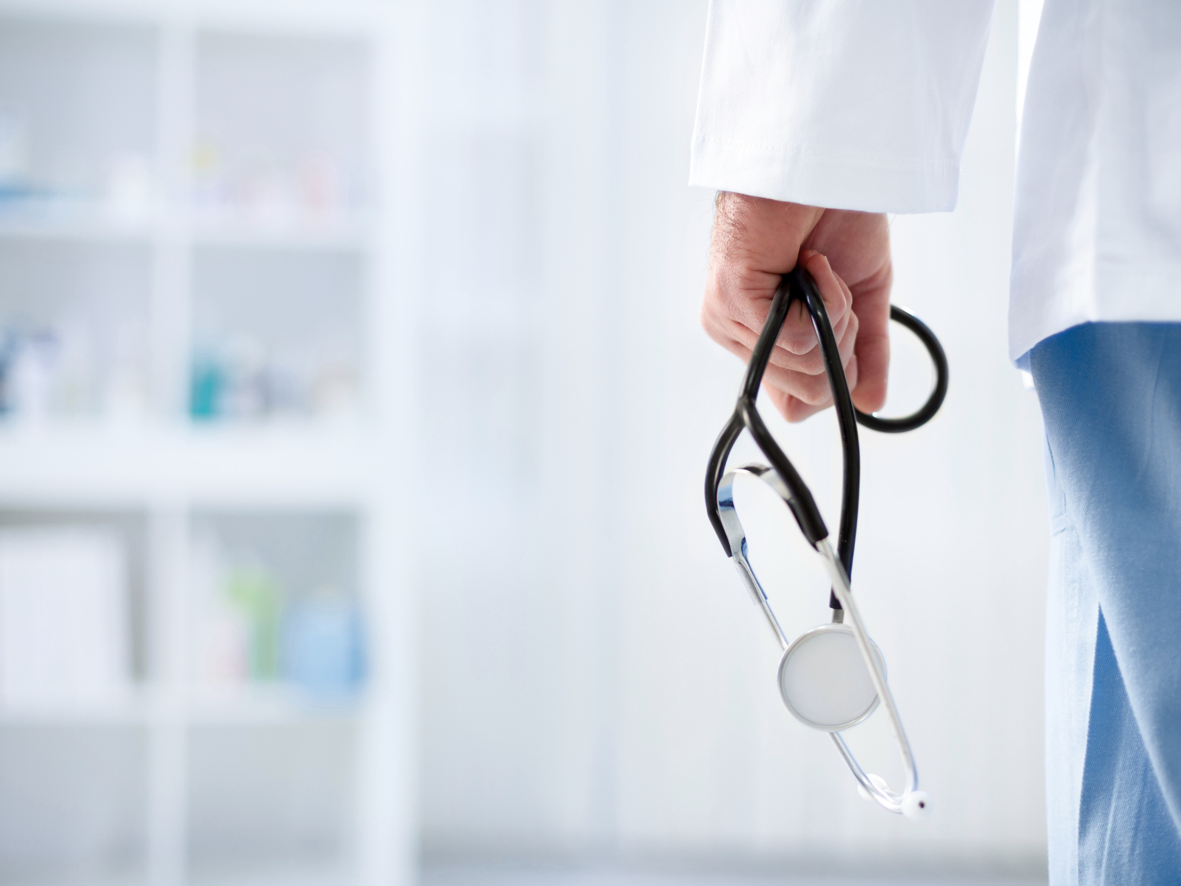 Healthcare professional holding stethoscope in modern hospital environment